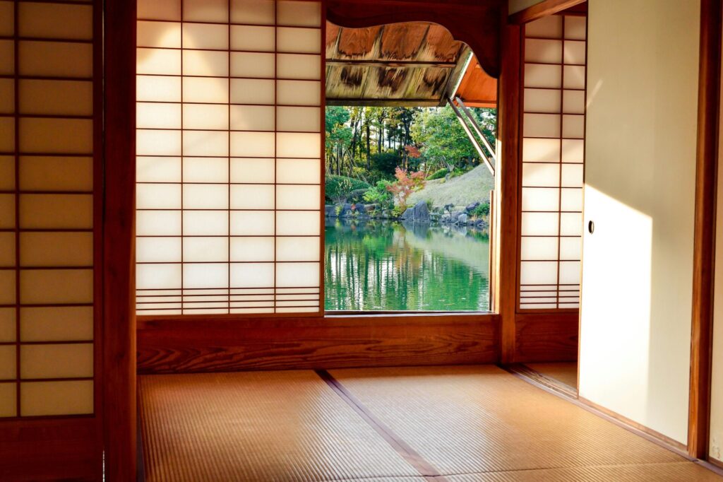 Traditional Japanese room with shoji screens and a view of a serene garden pond.